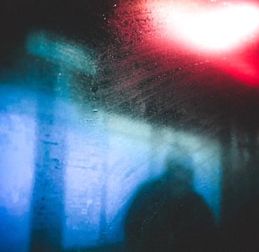 Blurred red and blue light through train window in rain