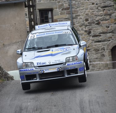Une Renault Clio Maxi aux couleurs d'origine "diac" en plein saut lors du rallye de Bagnols les Bain