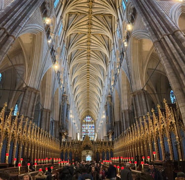 Gothic architecture of Westminster Abbey nave featuring vaulted ceilings and golden quire stalls.