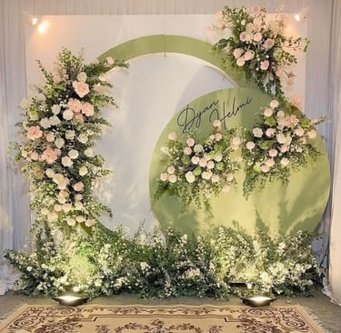 a wedding ceremony with a large green circle with flowers