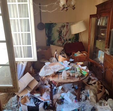 Débarras Lepeltier - Une pièce encombrée, avec des vêtements, des livres et des objets éparpillés partout.