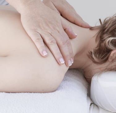 Professional massage therapist performing a deep tissue neck and shoulder massage for relaxation.