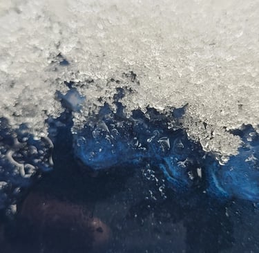 close up picture of ice melting off a blue metal surface