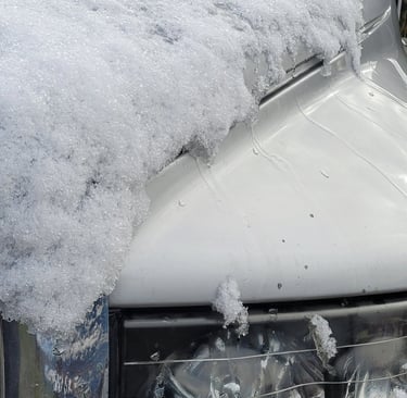close up picture of snow melting off the hood of a truck