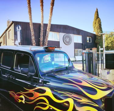 Taxi anglais noir avec flaming personnalisé stationné devant la façade de L'Entrepotes Conceptstore.