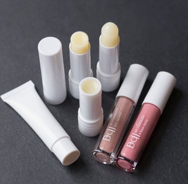 Close-up of handcrafted lip balm jars with natural ingredients around them on a wooden table