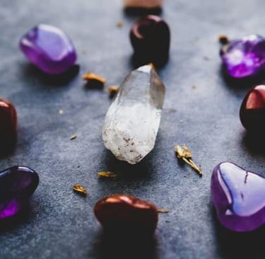 Cristales de sanación pulidos, dispuestos en círculo sobre superficie oscura.