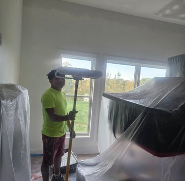 a man in a big room painting with a big roll!