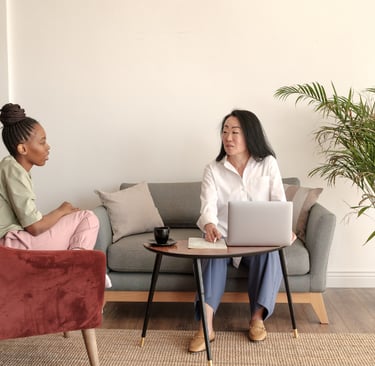 two women sitting on a couch in a living room