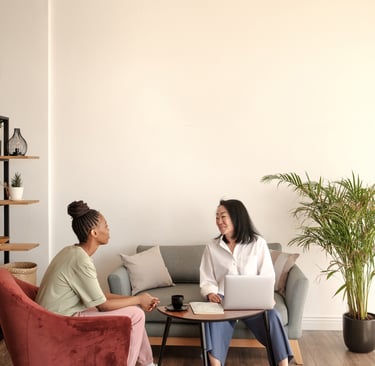 a woman sitting on a couch talking to a woman