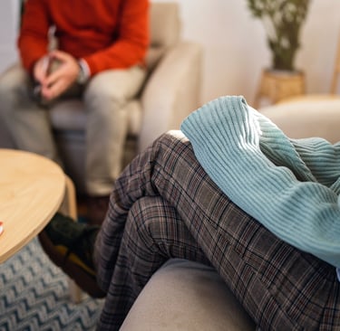Two people in a comfortable therapy session, representing telehealth therapy with Paula Fontenelle