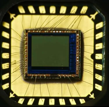 Close-up image of a semiconductor die with gold wire bonding inside a 28QFN package, showing bond pads and fine interconnect 