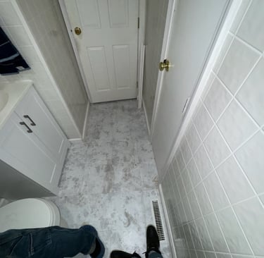 Small bathroom renovation featuring gray marbled floor tiles, white wall tiles, and a compact vanity.