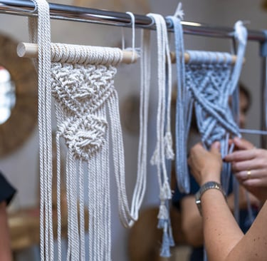 Proyecto de tapices de macramé hechos a mano colgados en un soporte metálico en un taller de macrame