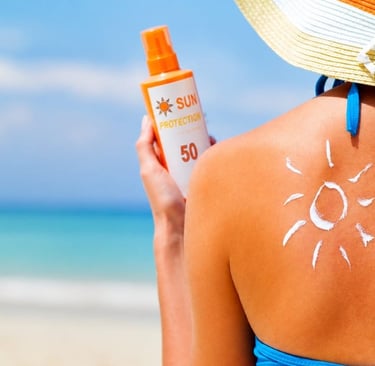 Una mujer en la playa se aplica crema protectora solar con factor de protección solar 50