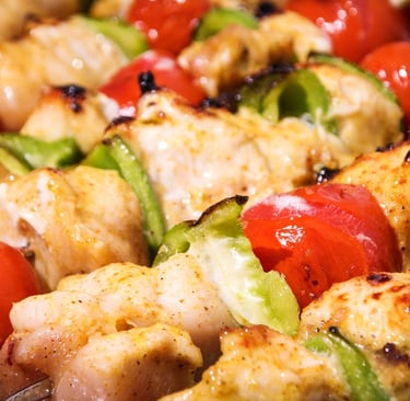 Close-up of grilled chicken skewers with bell peppers and tomatoes.