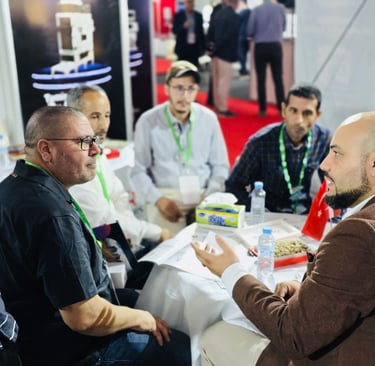 Business professionals at an international trade show discuss and network at a booth, showcasing global commerce and