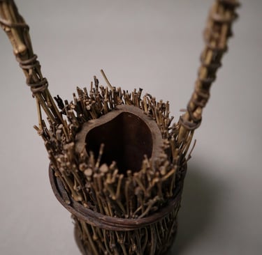 Handcrafted rustic flower vase made from bundled natural twigs and bamboo for organic home decor.