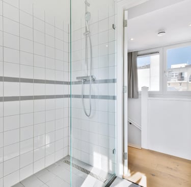 White‑tiled frameless shower, example of a frameless door in a contemporary Auckland bathroom