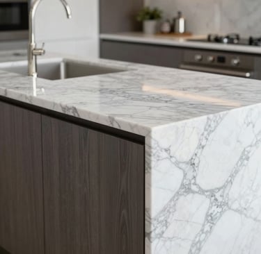 Modern luxury kitchen island featuring a white marble waterfall countertop and dark wood cabinets.
