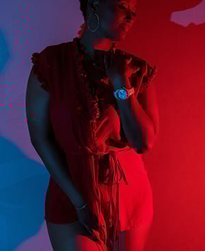 a woman in a red dress standing in front of a red light