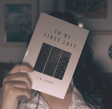J.R. Sonder holding her book TMFL over her face.