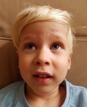 a young boy with blonde hair and a blue shirt