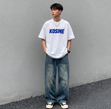 A stylish young man wearing a crisp, trendy shirt standing confidently in an urban setting.