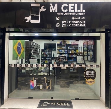 M Cell smartphone repair shop storefront with glass doors and mobile accessories on display.