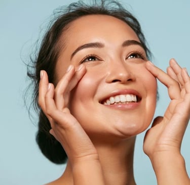 Mujer sonriente con piel radiante aplicando crema para los ojos en su rutina de hidratación facial.
