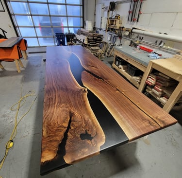 12ft x 4ft black walnut epoxy river boardroom table — in-shop production photo