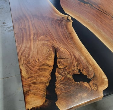 Black walnut black epoxy river boardroom table — wood grain and epoxy channel detail close-up
