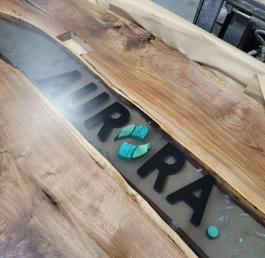 Custom Black Walnut boardroom table featuring a black epoxy river and natural live edge slabs
