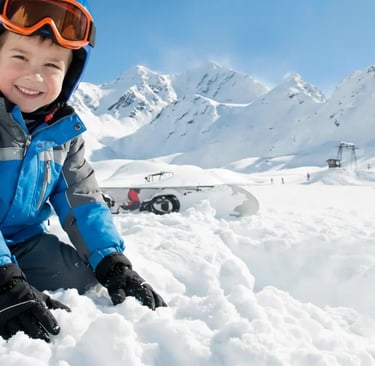 a young boy sitting in the snow with his snowboard el colorado chile