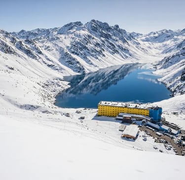 a large laguna del inca surrounded by mountains and snow portillo chile