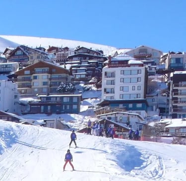 a group of people skiing down a hill la parva and valle nevado