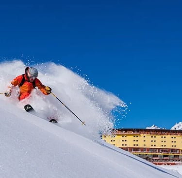 a person skiing down a snowy mountain slope in portillo chile