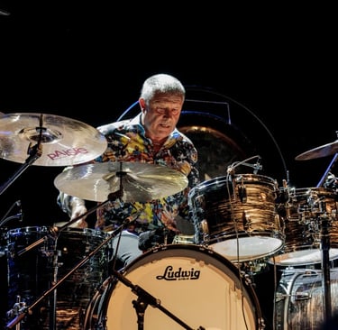 Registro fotográfico de Carl Palmer atrás de seu imponente kit de bateria.