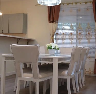 Shared dining room in adult family home with glass table and seating for resident meals.