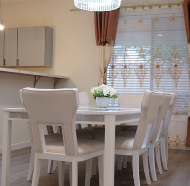 Shared dining room in adult family home with glass table and seating for resident meals.