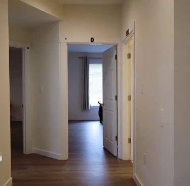 Private suites in adult family home with bed, seating area, and personal storage for resident comfort.