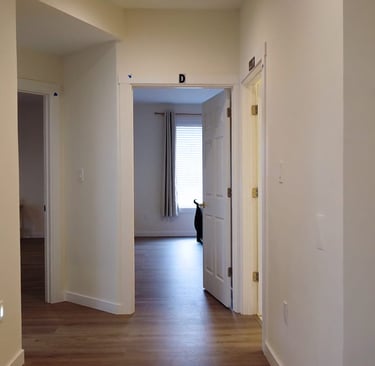 Private suites in adult family home with bed, seating area, and personal storage for resident comfort.