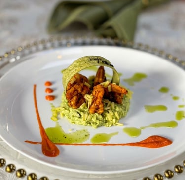 Gourmet grilled shrimp appetizer served on a bed of creamy avocado mousse with red pepper coulis.