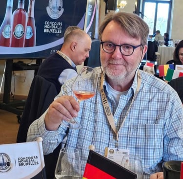 A wine judge holding a glass of rosé at the Concours Mondial de Bruxelles international competition.
