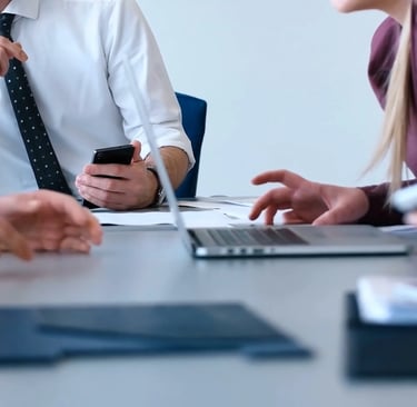 A distracted office leader checking phone notifications during a professional meeting