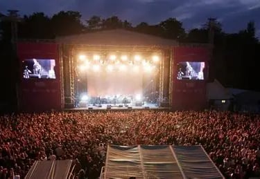 a views of the stage at the open air theatre at Scarborough. There is a show on. Bright stage lights