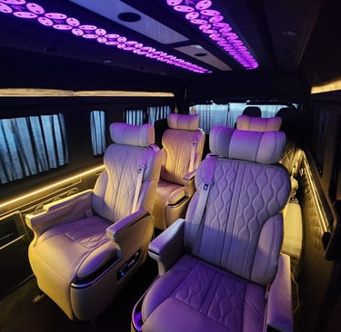 Luxury Premio van interior with leather reclining seats and purple LED ceiling lights.