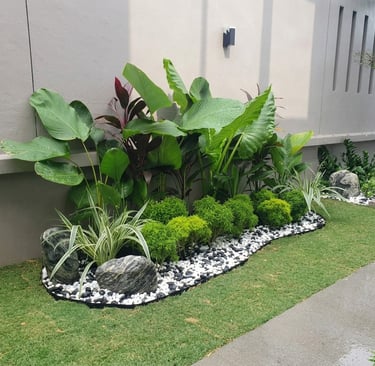 Tropical garden bed with white pebbles and artificial turf – Yie Yang Landscape