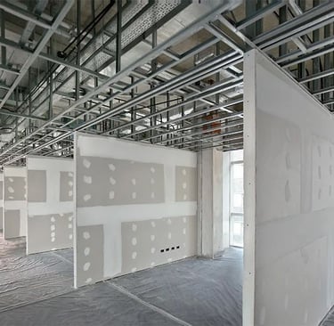 Taping jointer. Interior commercial construction work with metal ceiling structures and partitions.