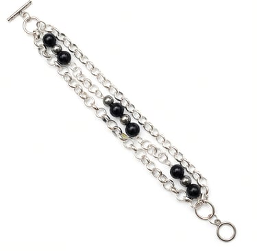 Multi-strand silver chain bracelet featuring black onyx beads and a secure toggle clasp.